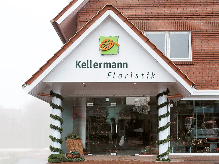 Foto: Eingang zum Ladengeschäft, Giebelgestaltung: 3-dimensionales Logo aus stilisiertem Blatt