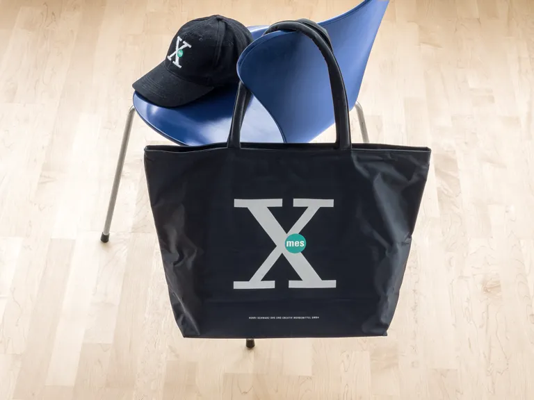 Foto: Shopper schwarz mit Logo Siebdruck 3-farbig, Cappy schwarz mit Logo Bestickung.