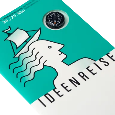 Foto: Illustratives Key Visual der Ideenreise. Ein Mensch mit einem Boot unter vollem Segel auf dem Kopf.